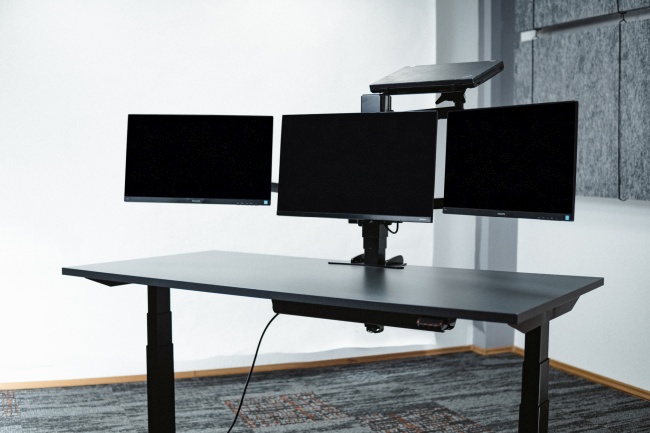 Trīs ekrāni + laptops dokstacijā virs ekrāniem